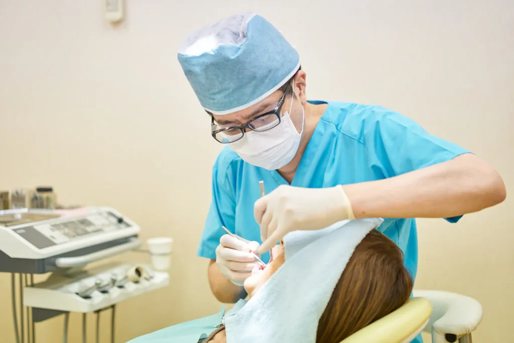 Nha sĩ đeo găng tay latex màu trắng ngà thao tác chính xác trong miệng bệnh nhân